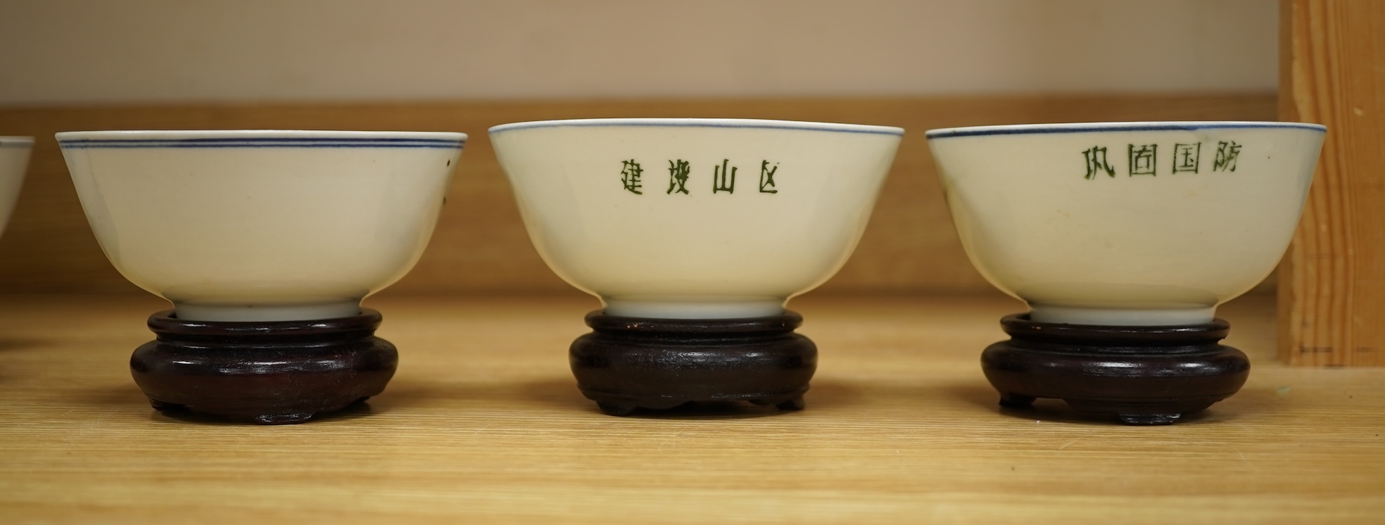 A Chinese Cultural Revolution porcelain teapot, six bowls, wood stands and an enamel tray-29.5cm diameter. (8)